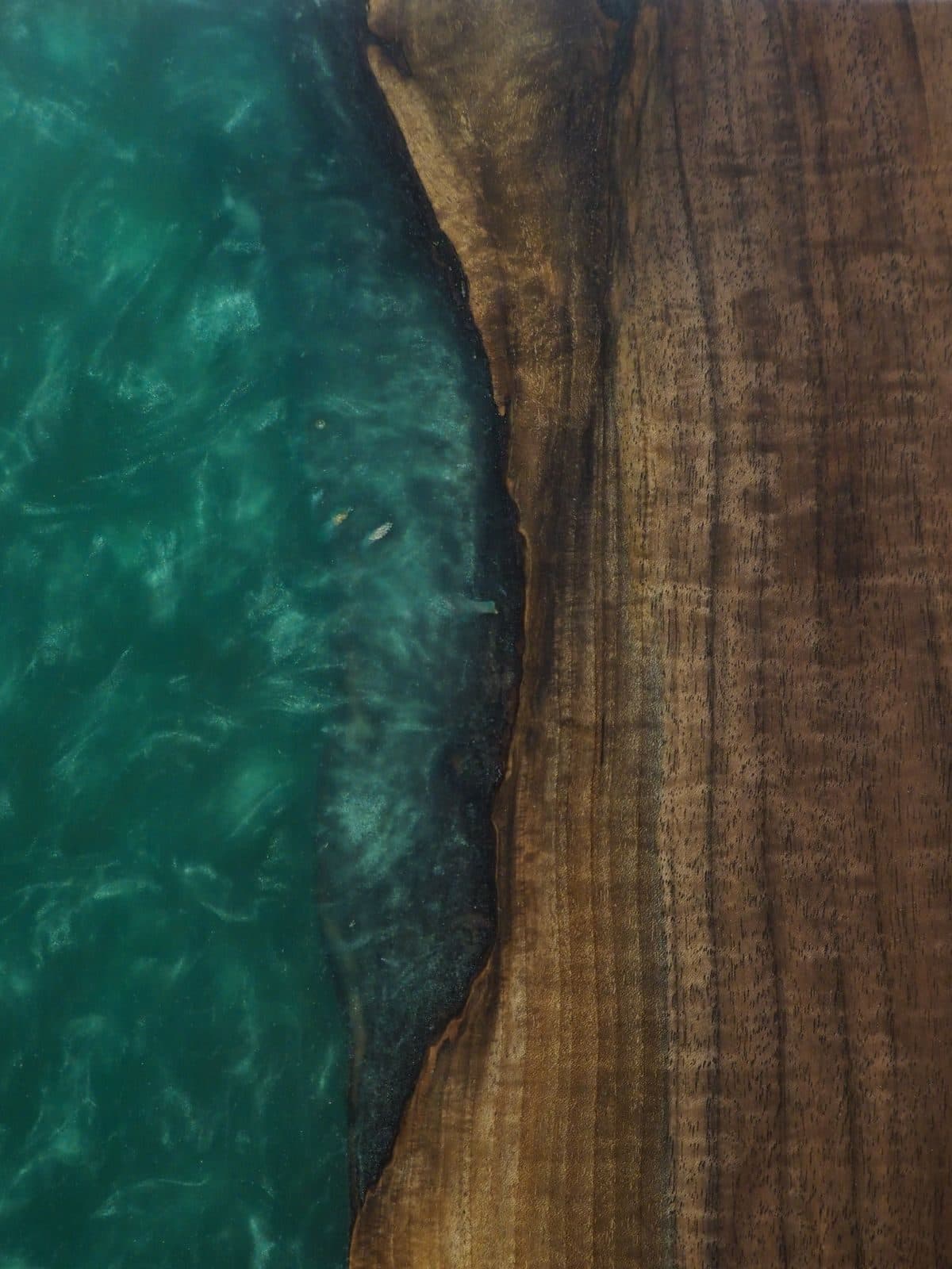 Close-up of a live-edge table with green epoxy river