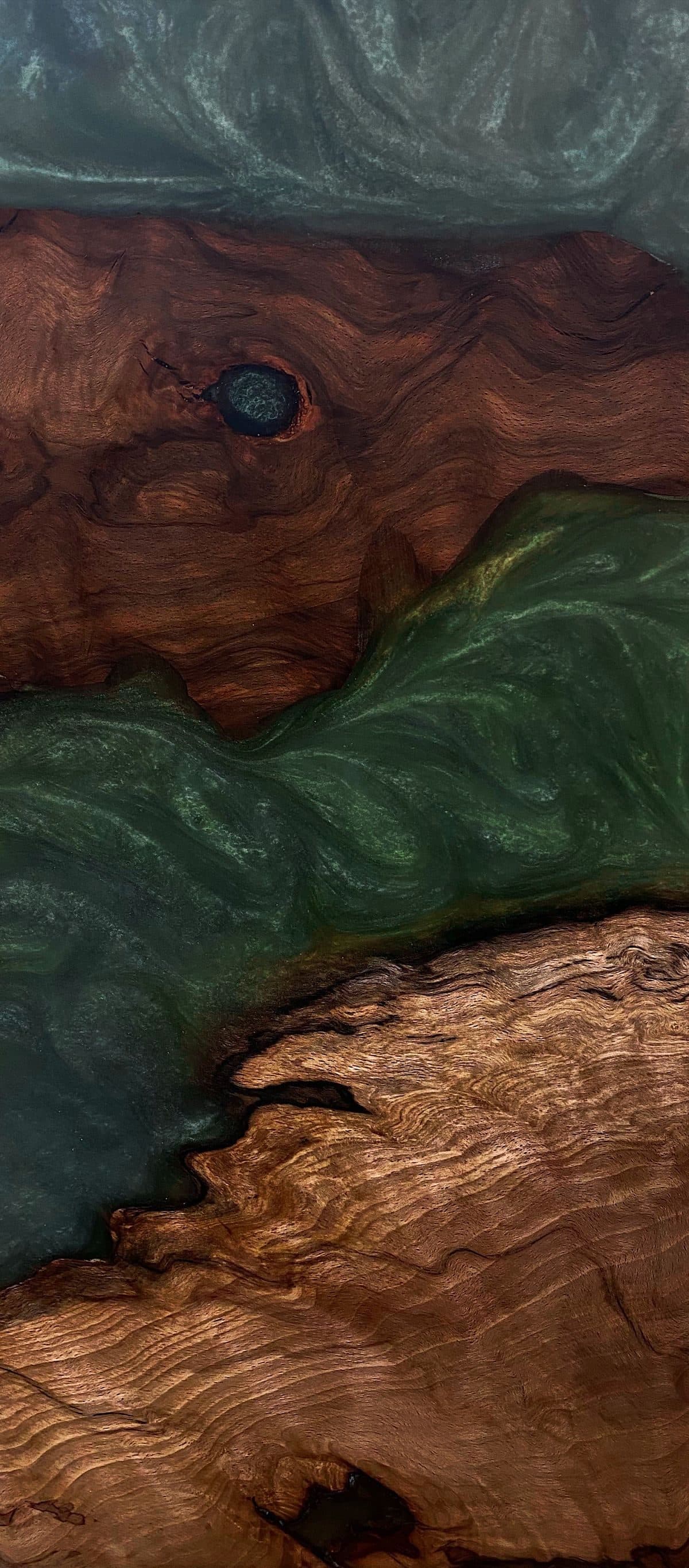 Portrait-crop detail of a walnut slab with green figure accent